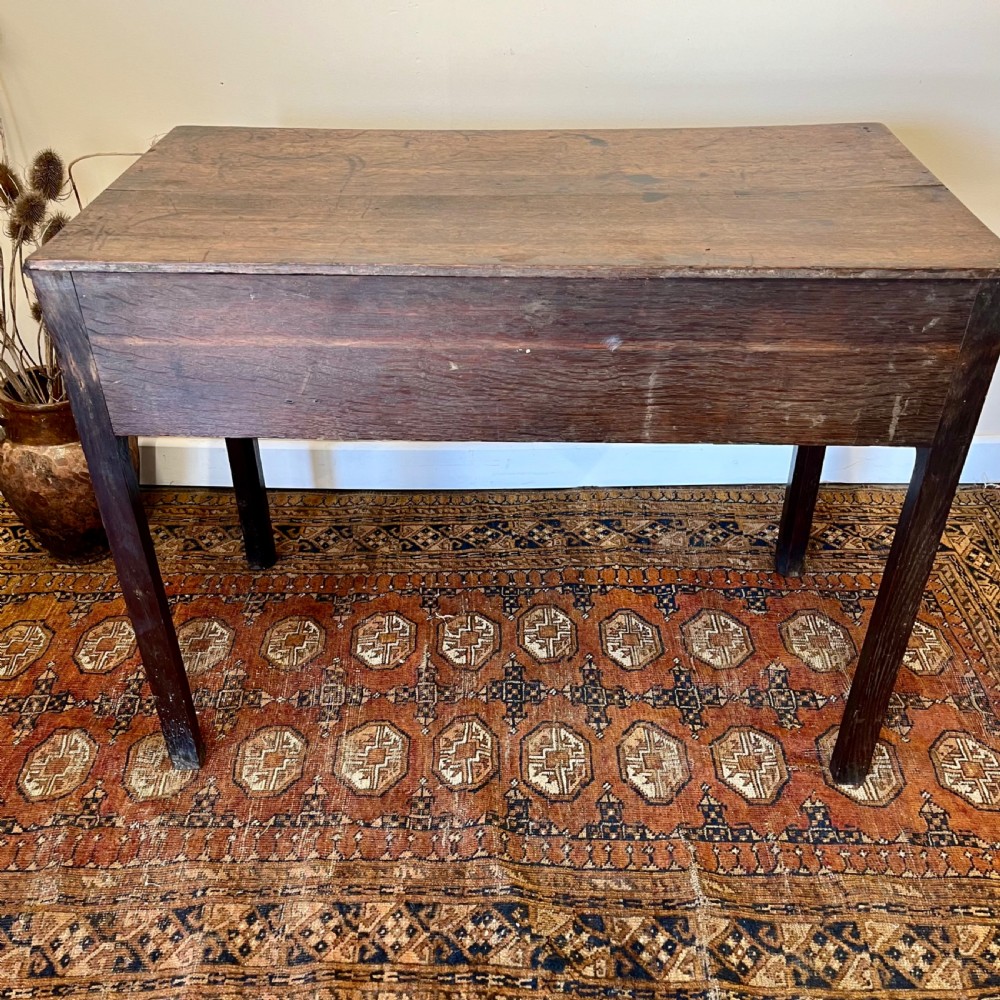 An 18th-century Georgian dark oak lowboy table featuring three drawers with brass swan-neck handles and a shaped frieze. View VIII