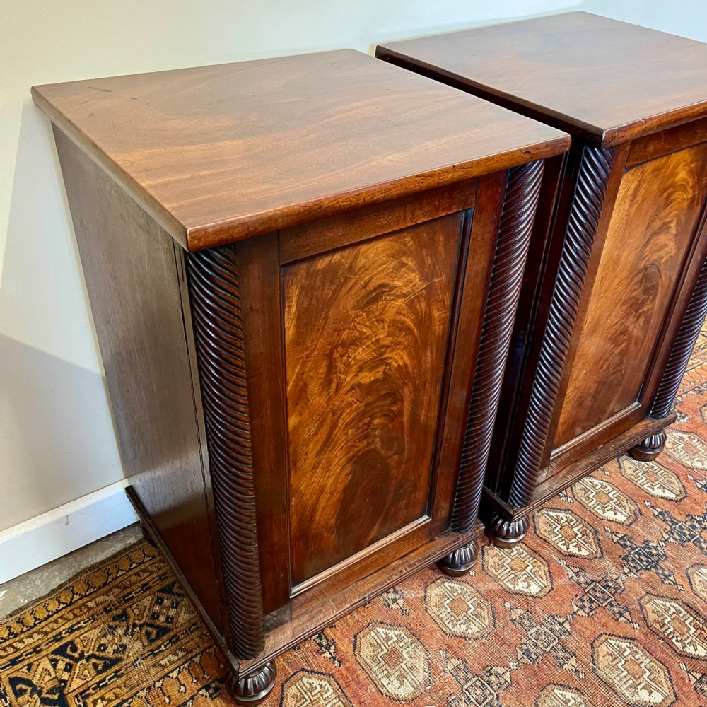 A pair of 19th-century mahogany bedside cupboards featuring flame mahogany panel doors, rope-twist carved side details, and turned feet. View VIII