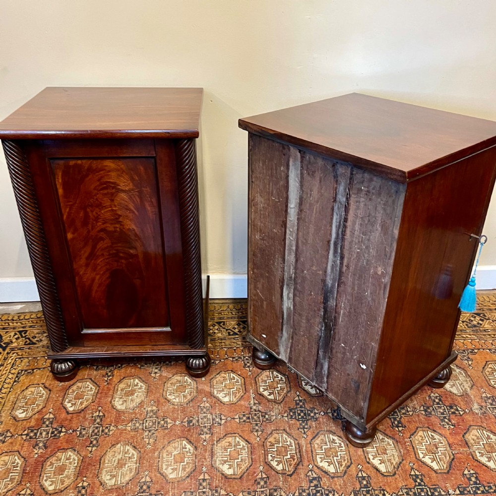A pair of 19th-century mahogany bedside cupboards featuring flame mahogany panel doors, rope-twist carved side details, and turned feet. View IX