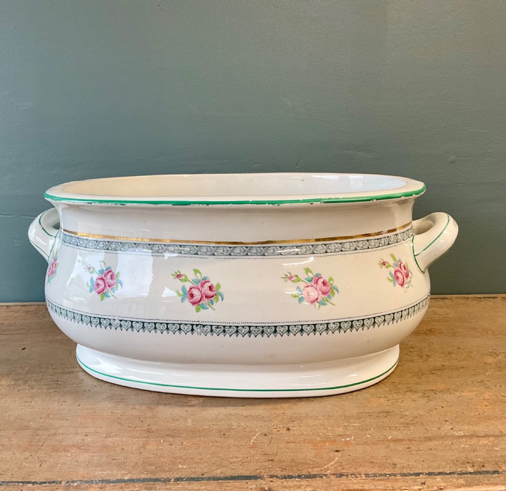 A Victorian oval ceramic footbath featuring hand-painted pink floral motifs, green trim, gilding, and twin looped handles. View II
