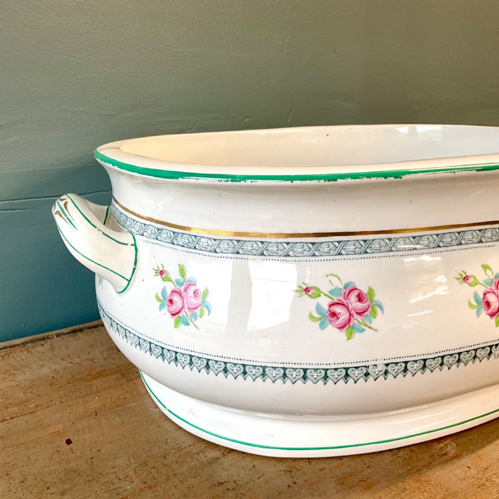 A Victorian oval ceramic footbath featuring hand-painted pink floral motifs, green trim, gilding, and twin looped handles. View III