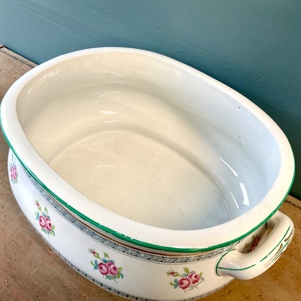 A Victorian oval ceramic footbath featuring hand-painted pink floral motifs, green trim, gilding, and twin looped handles. View IV