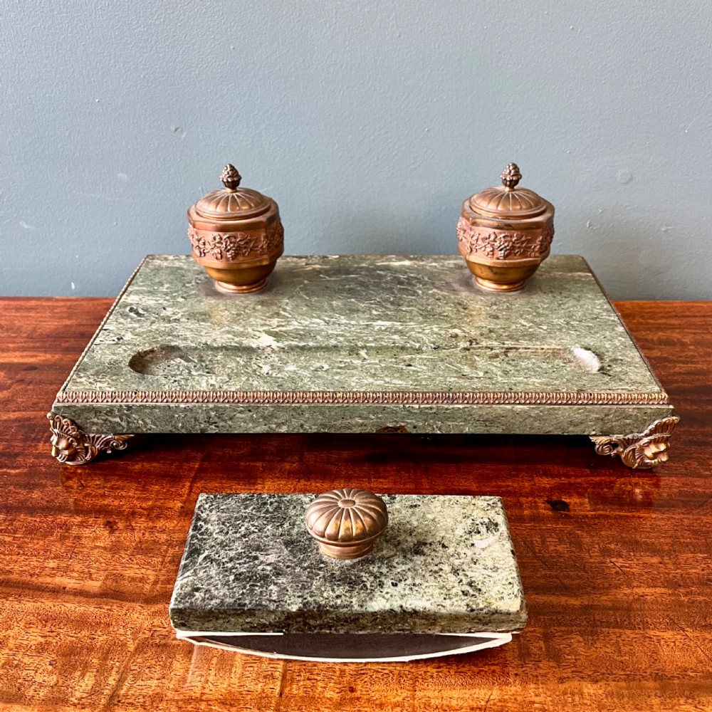 A French green marble desk set featuring a rectangular inkstand base with two raised gilt ormolu inkwells, a carved pen tray, ornate corner feet, and a matching marble rocking blotter. View II