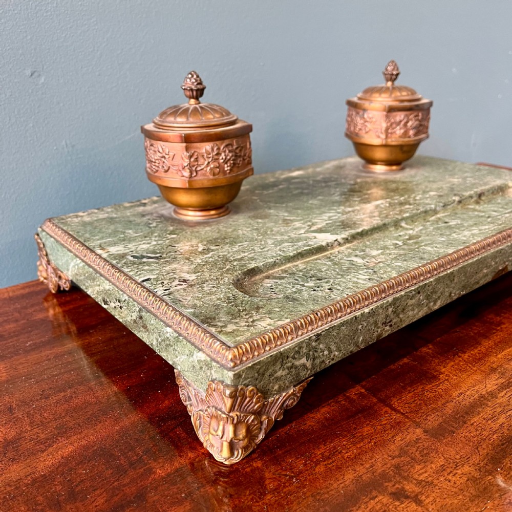 A French green marble desk set featuring a rectangular inkstand base with two raised gilt ormolu inkwells, a carved pen tray, ornate corner feet, and a matching marble rocking blotter. View III