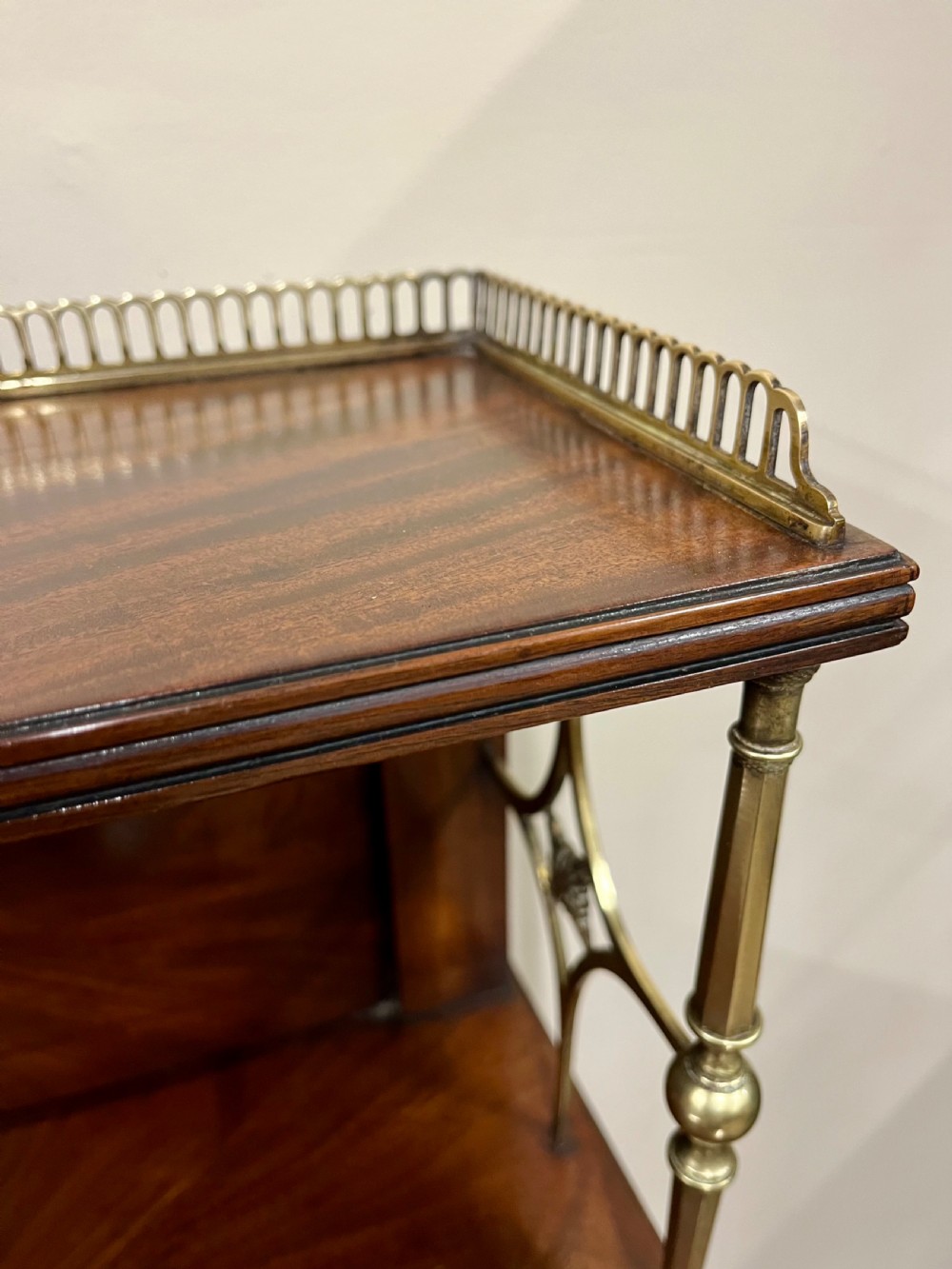 A 19th-century mahogany chiffonier featuring an upper shelf with a brass gallery, twin panelled cupboard doors flanked by turned side columns, resting on bun feet. View VII