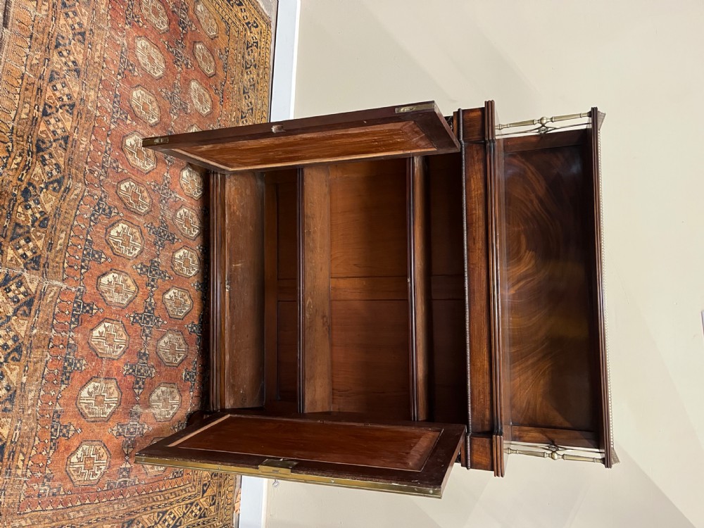 A 19th-century mahogany chiffonier featuring an upper shelf with a brass gallery, twin panelled cupboard doors flanked by turned side columns, resting on bun feet. View VIII
