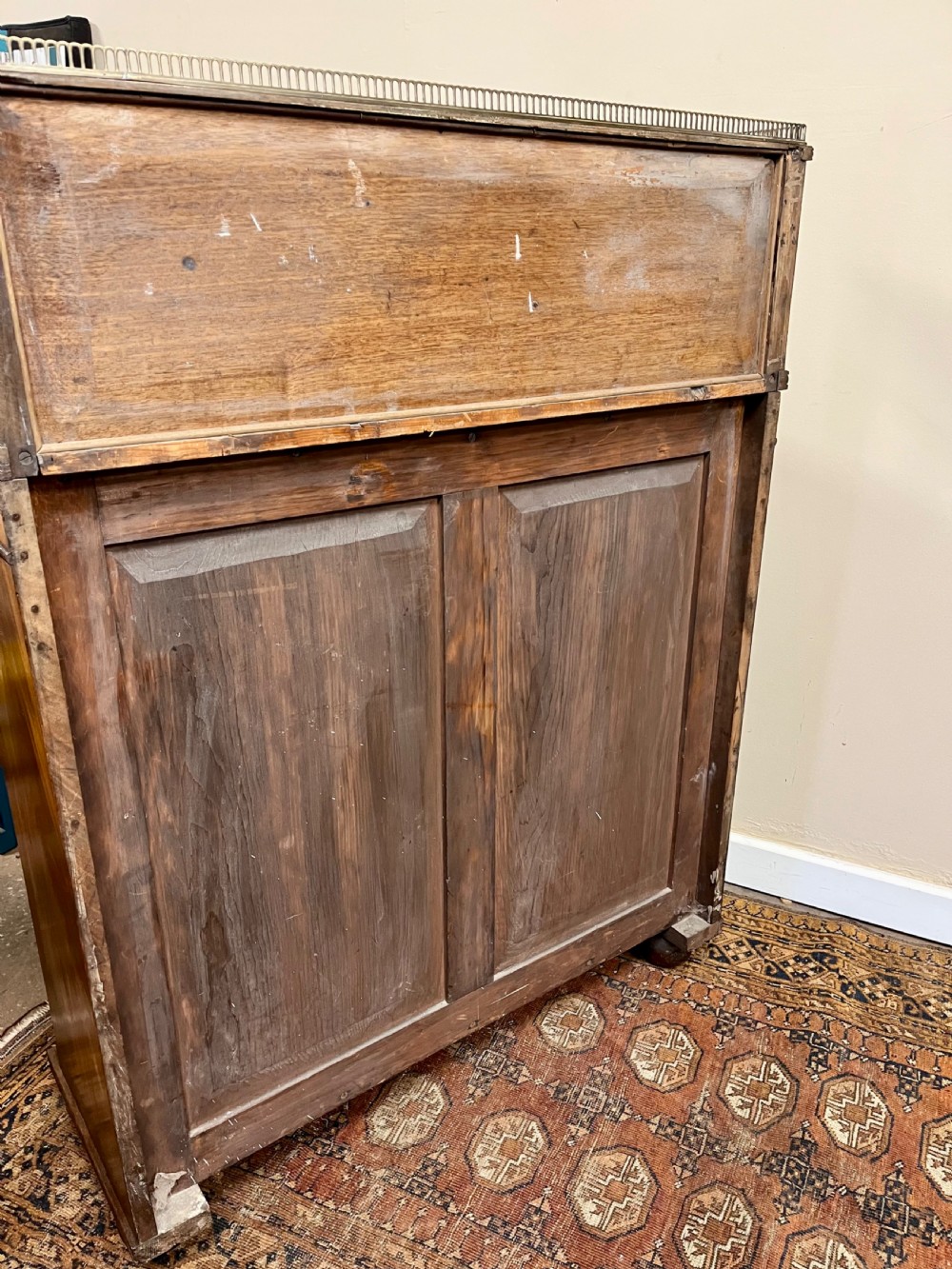A 19th-century mahogany chiffonier featuring an upper shelf with a brass gallery, twin panelled cupboard doors flanked by turned side columns, resting on bun feet. View XII