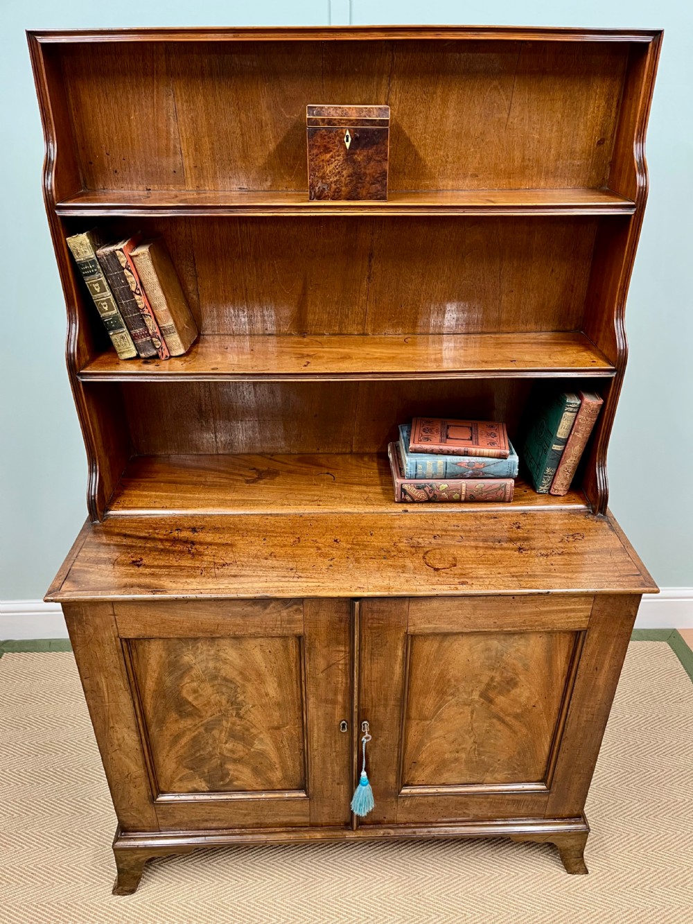 A 19th-century mahogany waterfall bookcase with three graduated open shelves over a two-door cabinet resting on bracket feet. View III