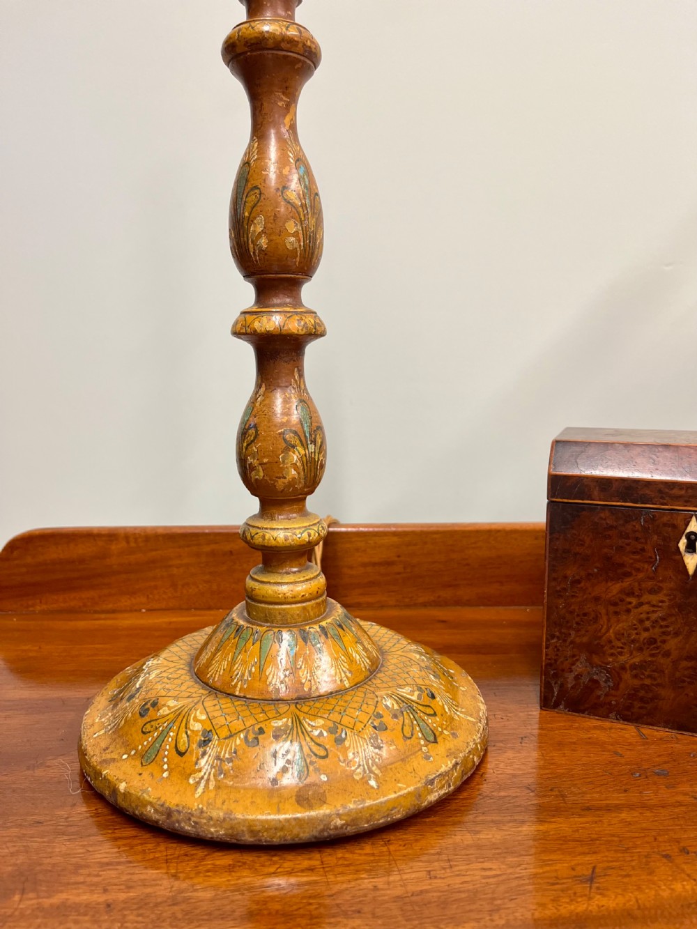 A 19th-century turned wooden Kashmiri table lamp base featuring hand-painted floral motifs in ochre, green, and white with a brass light fitting. View II