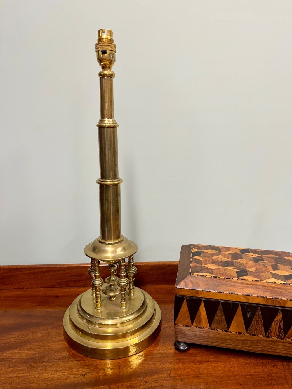 An antique turned brass Secessionist table lamp base featuring a stepped circular pedestal and miniature decorative columns around the lower stem. View III
