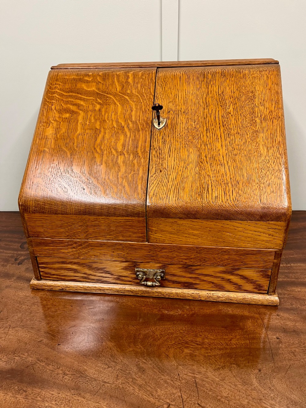A Victorian oak stationery cabinet with open doors showing stepped letter compartments, a built-in calendar mechanism, inkwell slots, and a lower drawer. View II