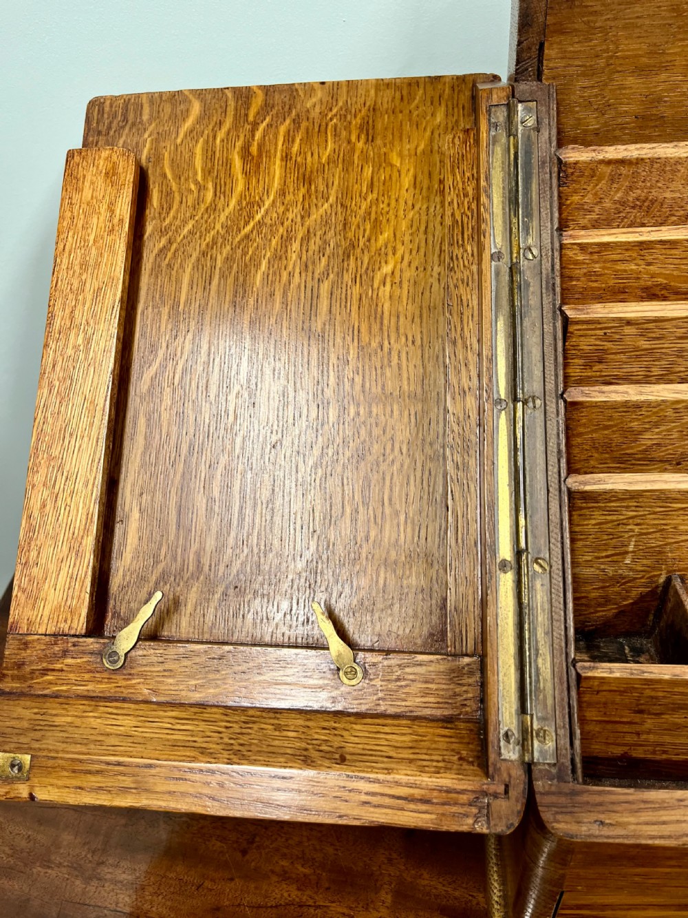 A Victorian oak stationery cabinet with open doors showing stepped letter compartments, a built-in calendar mechanism, inkwell slots, and a lower drawer. View V