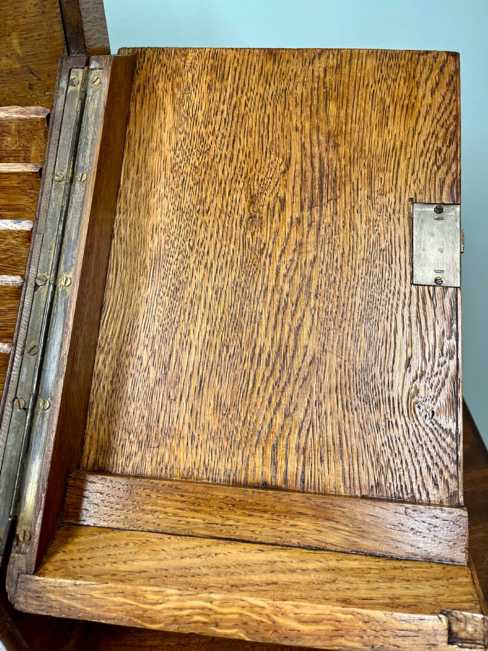 A Victorian oak stationery cabinet with open doors showing stepped letter compartments, a built-in calendar mechanism, inkwell slots, and a lower drawer. View VI