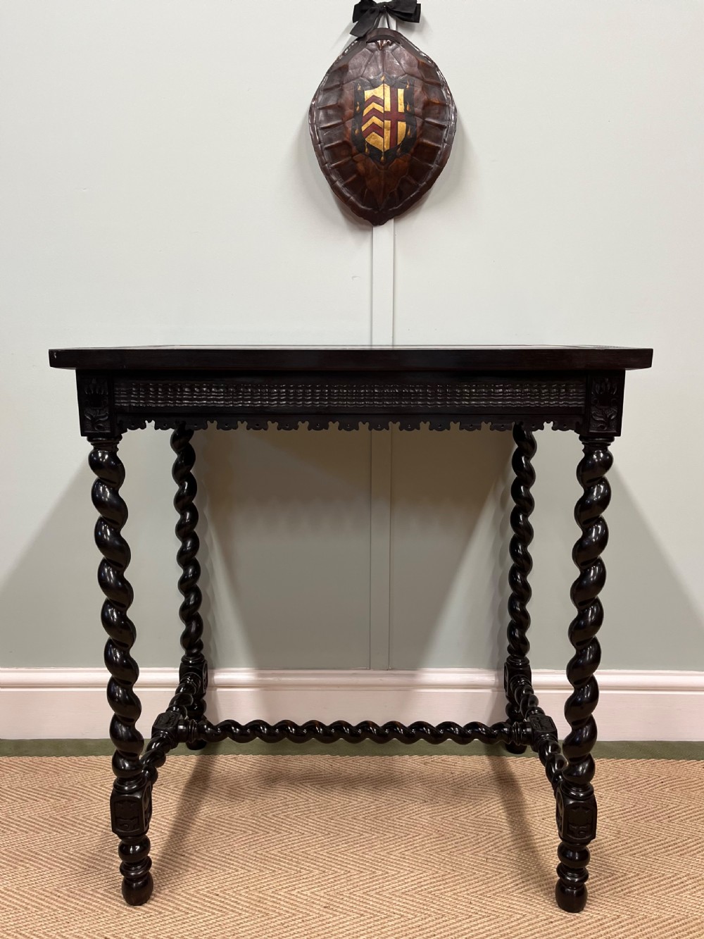 A 19th-century Spanish ebonised centre table featuring spiral barley twist legs, an under-stretcher, and an inset red leather top with gilded borders. View VI