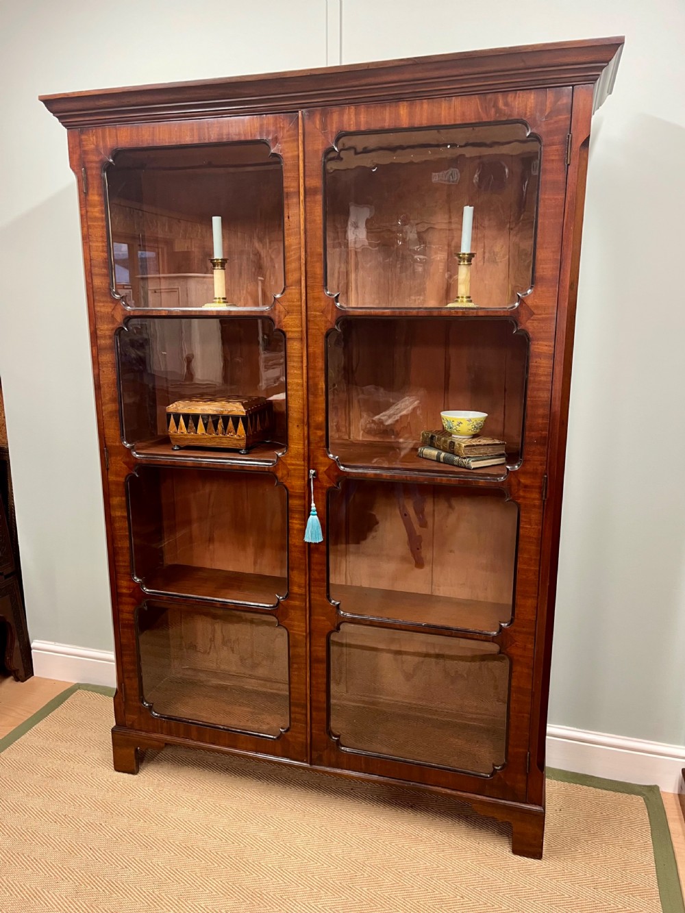 A tall 19th-century mahogany glazed bookcase featuring two double doors with multi-paned glass windows and a moulded top cornice.