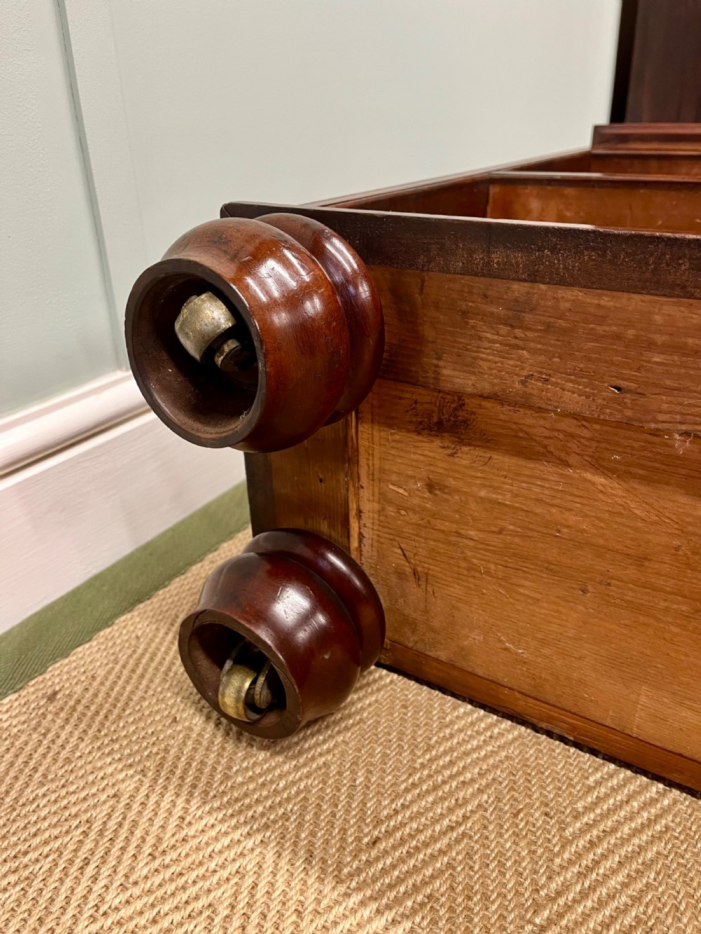 A low 19th-century mahogany bookcase featuring three small drawers above open shelving and supported by turned feet. View IX