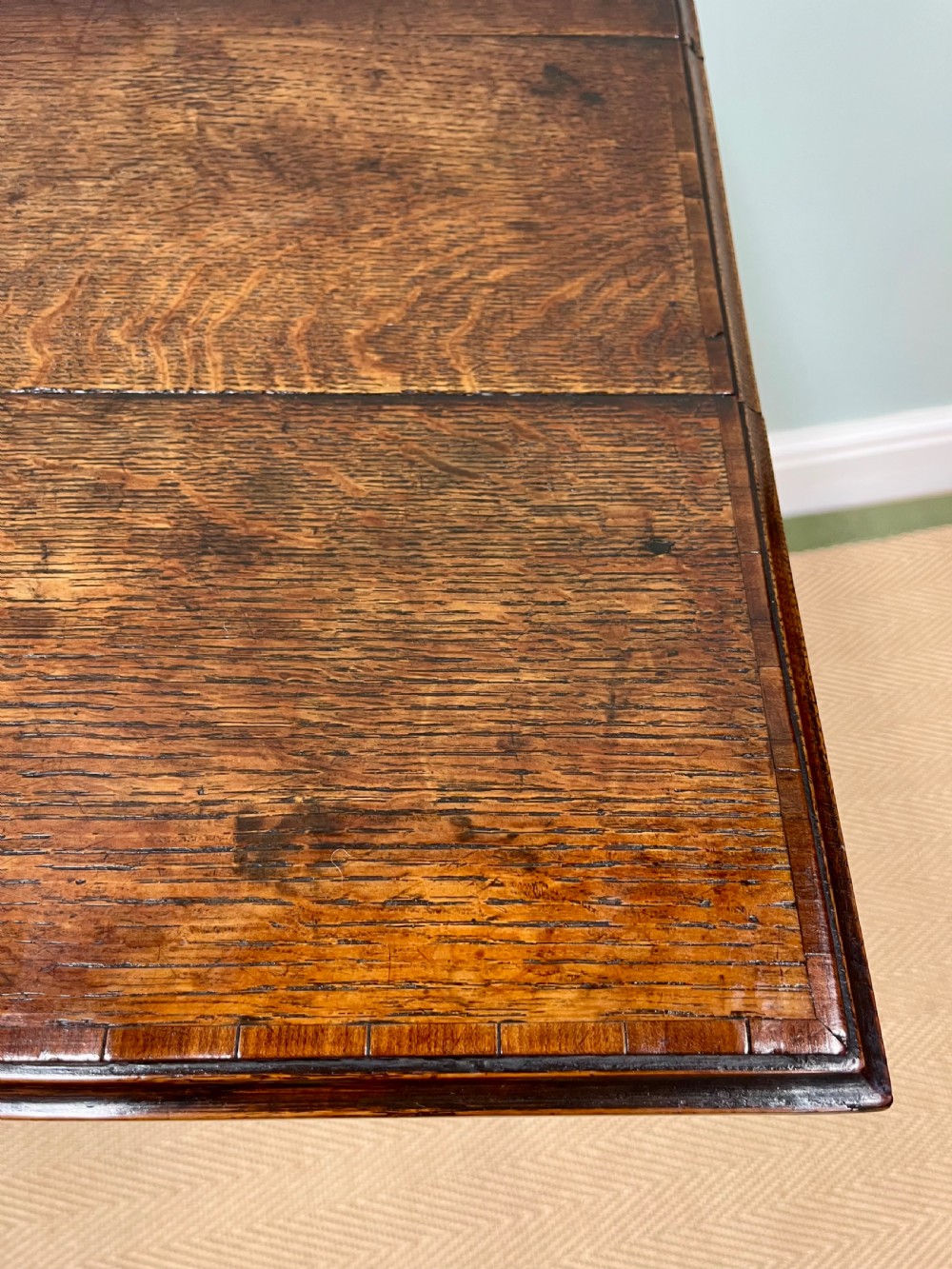 An 18th-century warm brown oak side table featuring a single drawer with a central brass handle and straight square legs. View V