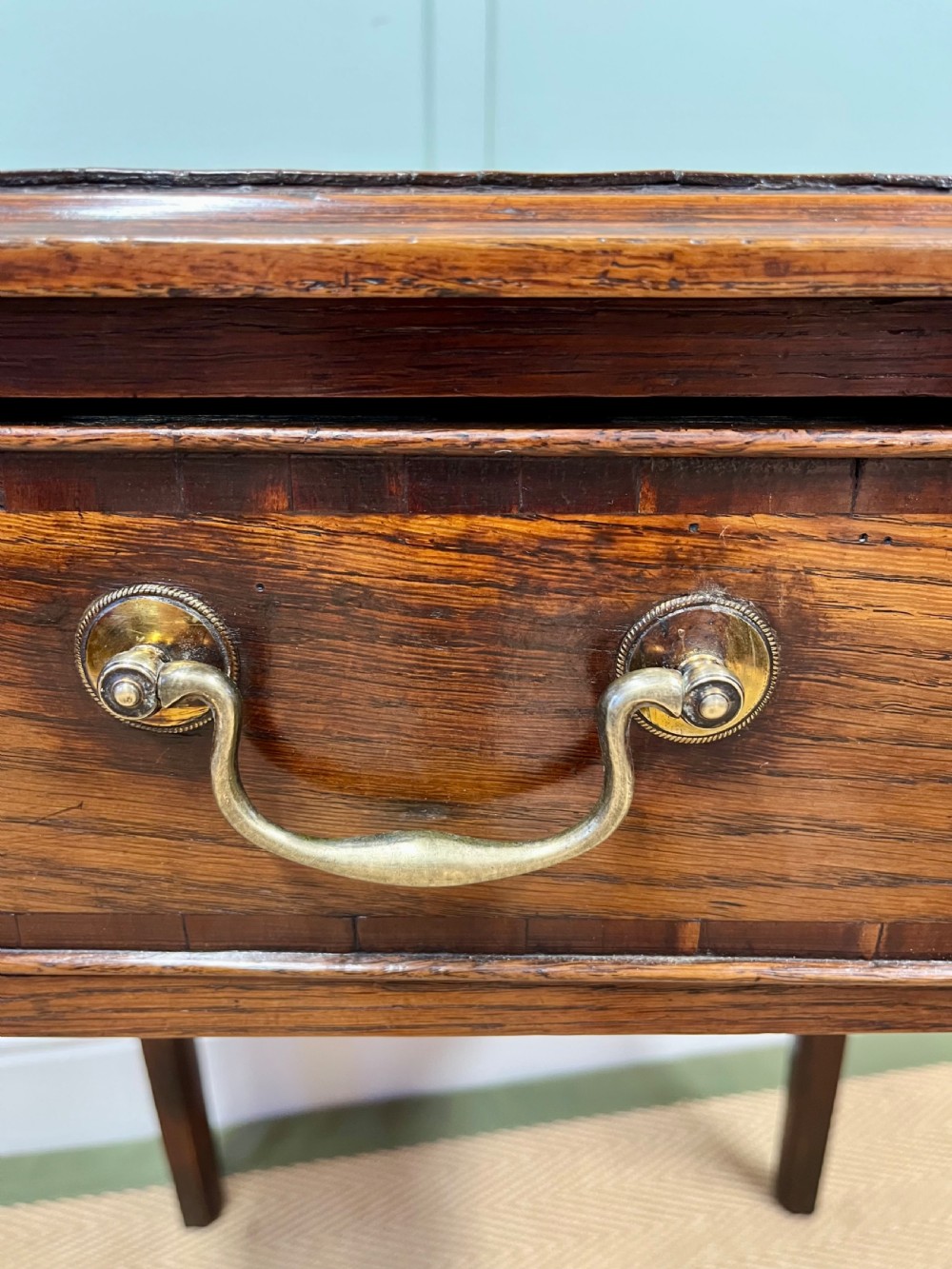 An 18th-century warm brown oak side table featuring a single drawer with a central brass handle and straight square legs. View VIII