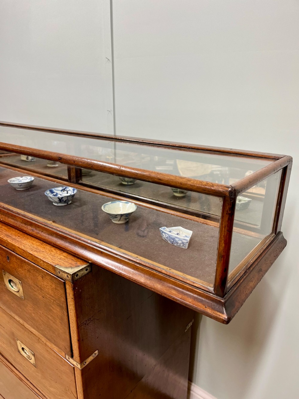 A long, low Victorian mahogany and glass tabletop display case with a moulded base and glazed panels. View II