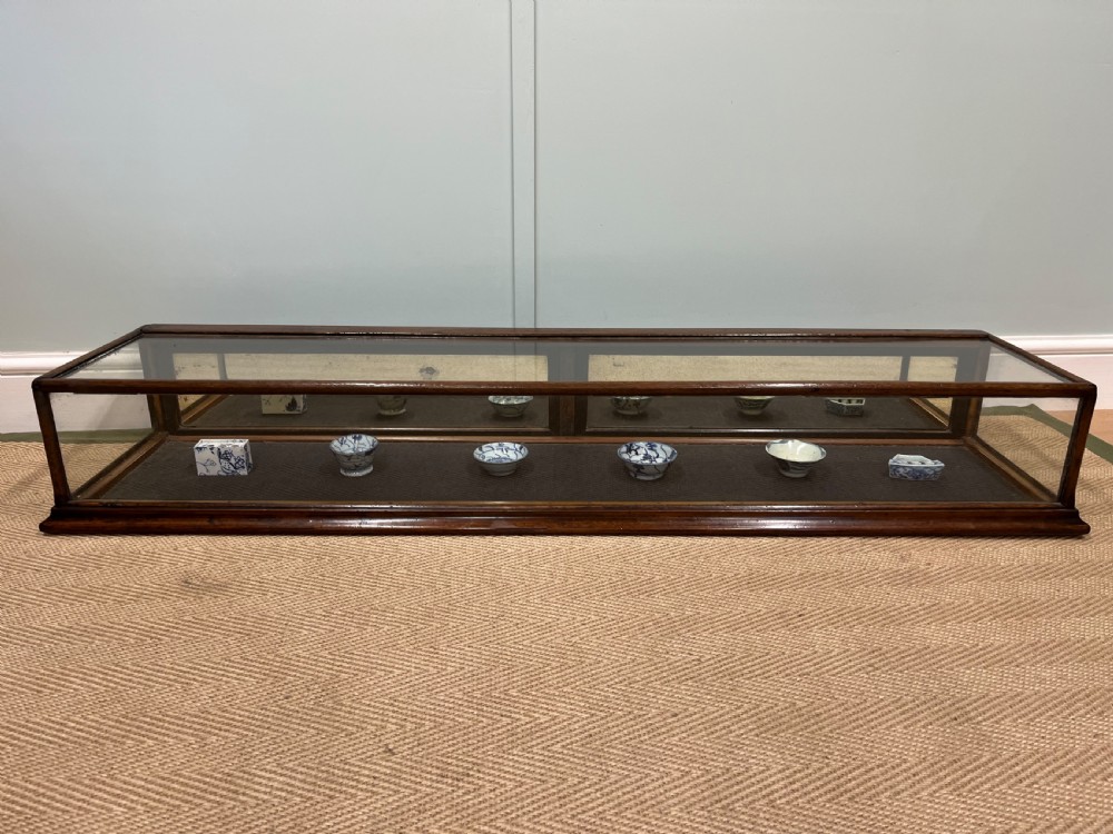A long, low Victorian mahogany and glass tabletop display case with a moulded base and glazed panels. View X