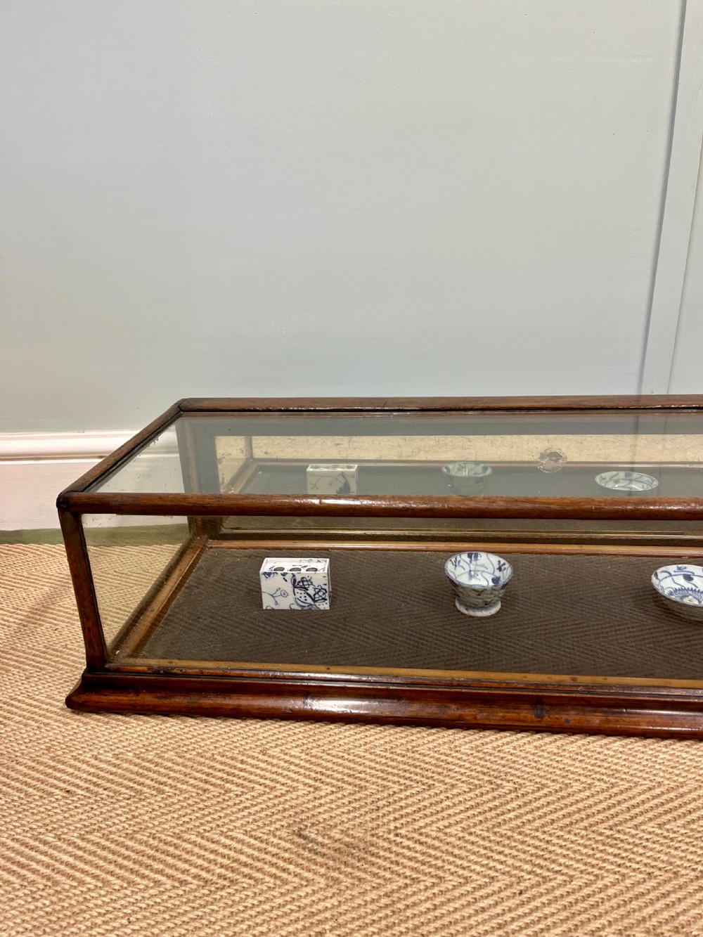 A long, low Victorian mahogany and glass tabletop display case with a moulded base and glazed panels. View XI