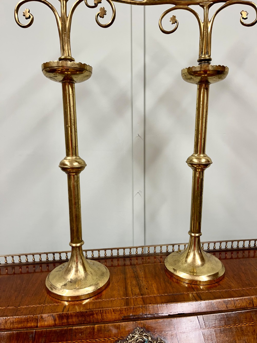 A pair of Gothic Revival brass candelabra featuring tall turned stems and sweeping multi-branch arms with scalloped drip pans. View II