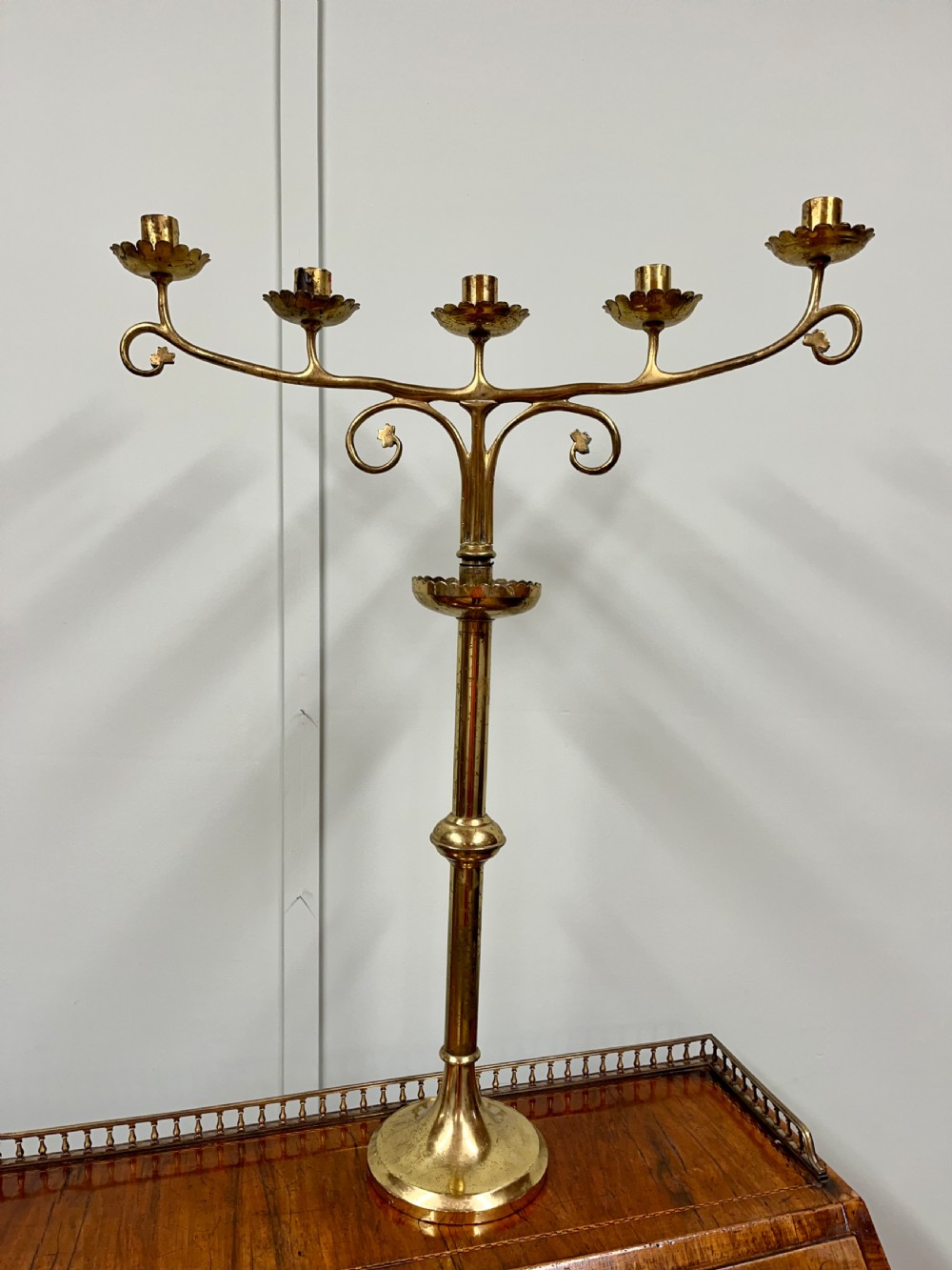 A pair of Gothic Revival brass candelabra featuring tall turned stems and sweeping multi-branch arms with scalloped drip pans. View III