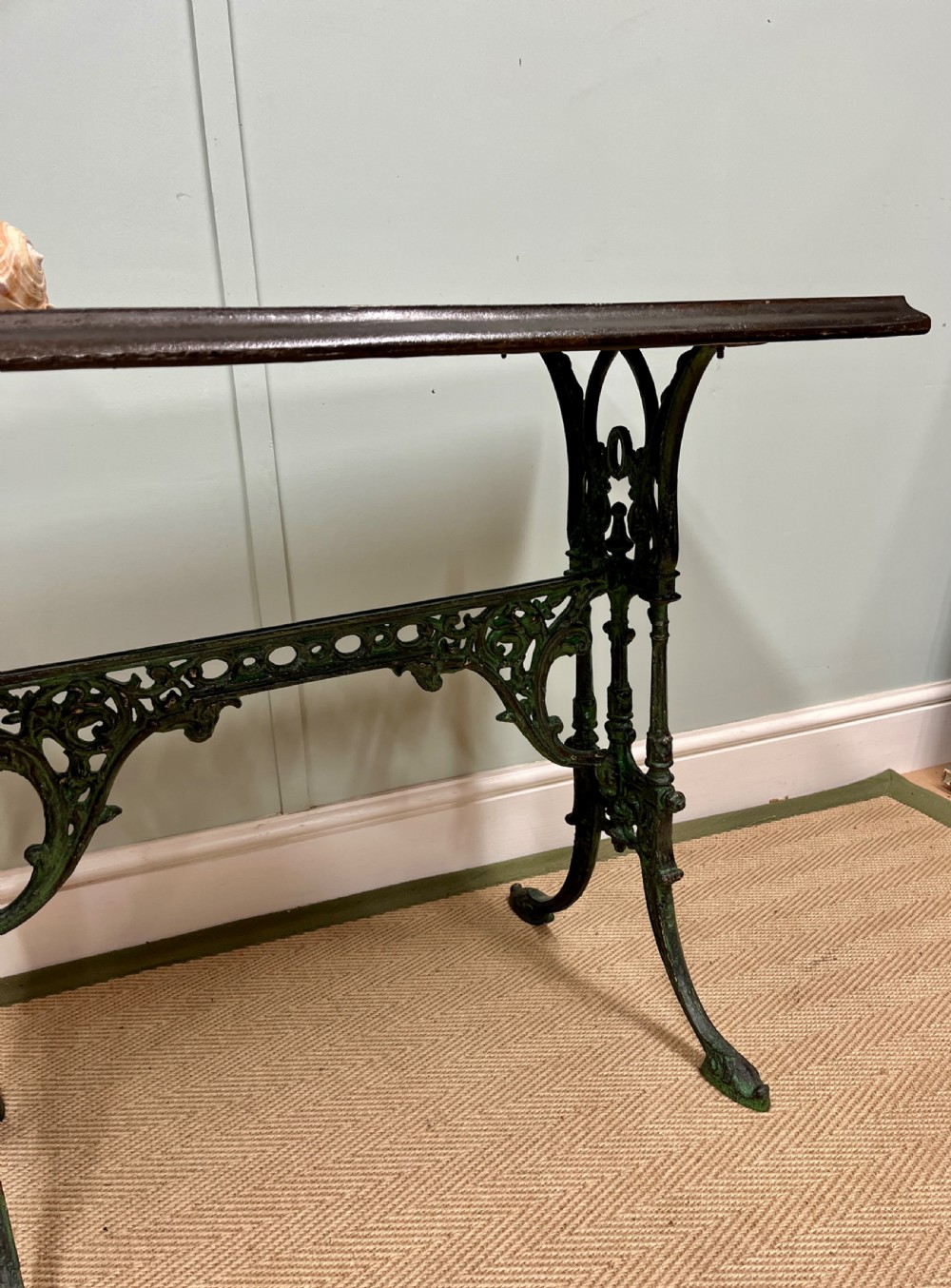 A 19th-century rectangular side table featuring a dark polished timber top supported by a dark green painted cast iron base with scrollwork decoration. View II