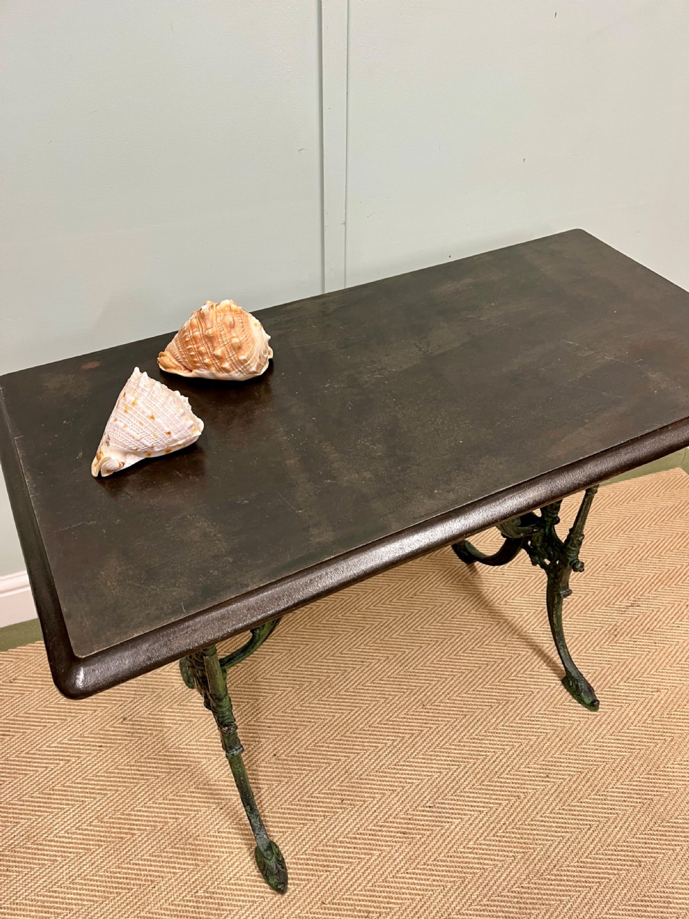 A 19th-century rectangular side table featuring a dark polished timber top supported by a dark green painted cast iron base with scrollwork decoration. View III