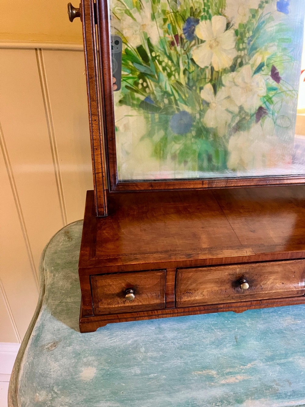 An Edwardian walnut toilet mirror with an arched glass frame held by turned upright posts on a three-drawer plinth base. View VI