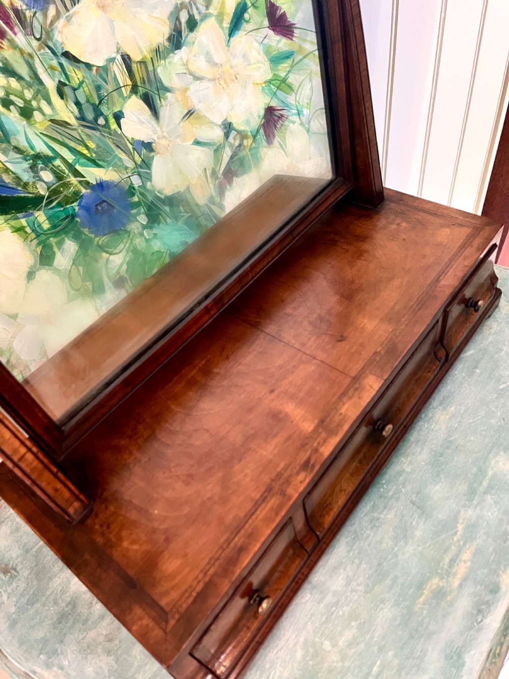 An Edwardian walnut toilet mirror with an arched glass frame held by turned upright posts on a three-drawer plinth base. View VII