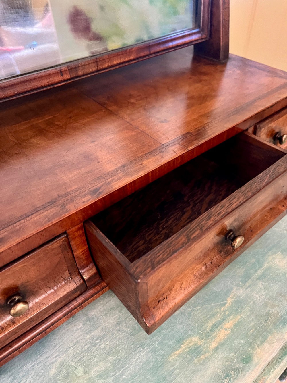 An Edwardian walnut toilet mirror with an arched glass frame held by turned upright posts on a three-drawer plinth base. View IX