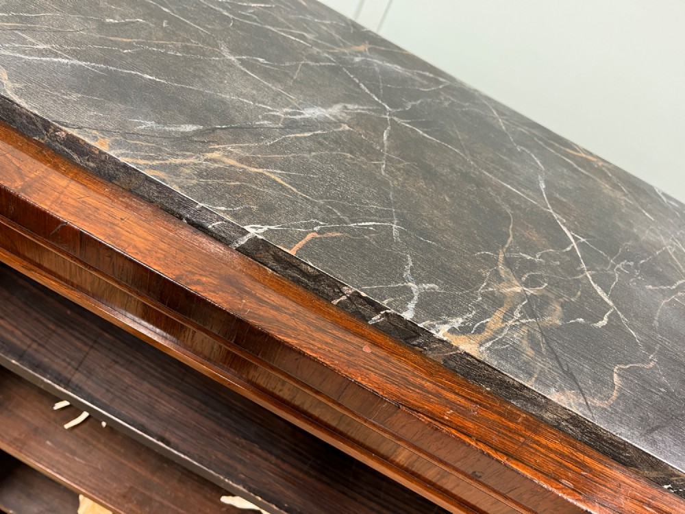 A George IV open rosewood dwarf bookcase featuring carved acanthus pilasters, four open shelves, and a grey marble top. View VII
