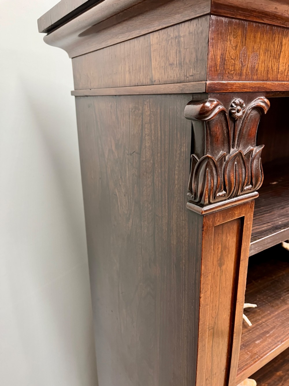 A George IV open rosewood dwarf bookcase featuring carved acanthus pilasters, four open shelves, and a grey marble top. View VIII