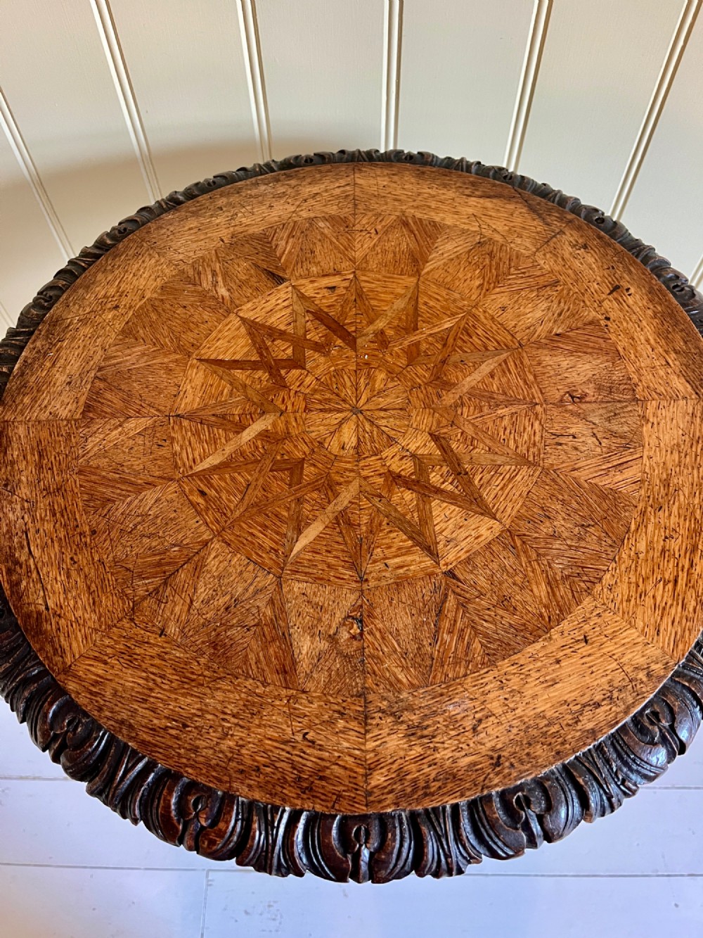 A 19th-century French oak round side table featuring a geometric parquetry top, carved rim, turned column pedestal, and carved tripod feet. View II