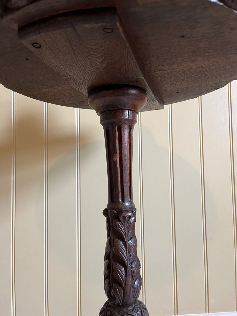 A 19th-century French oak round side table featuring a geometric parquetry top, carved rim, turned column pedestal, and carved tripod feet. View V
