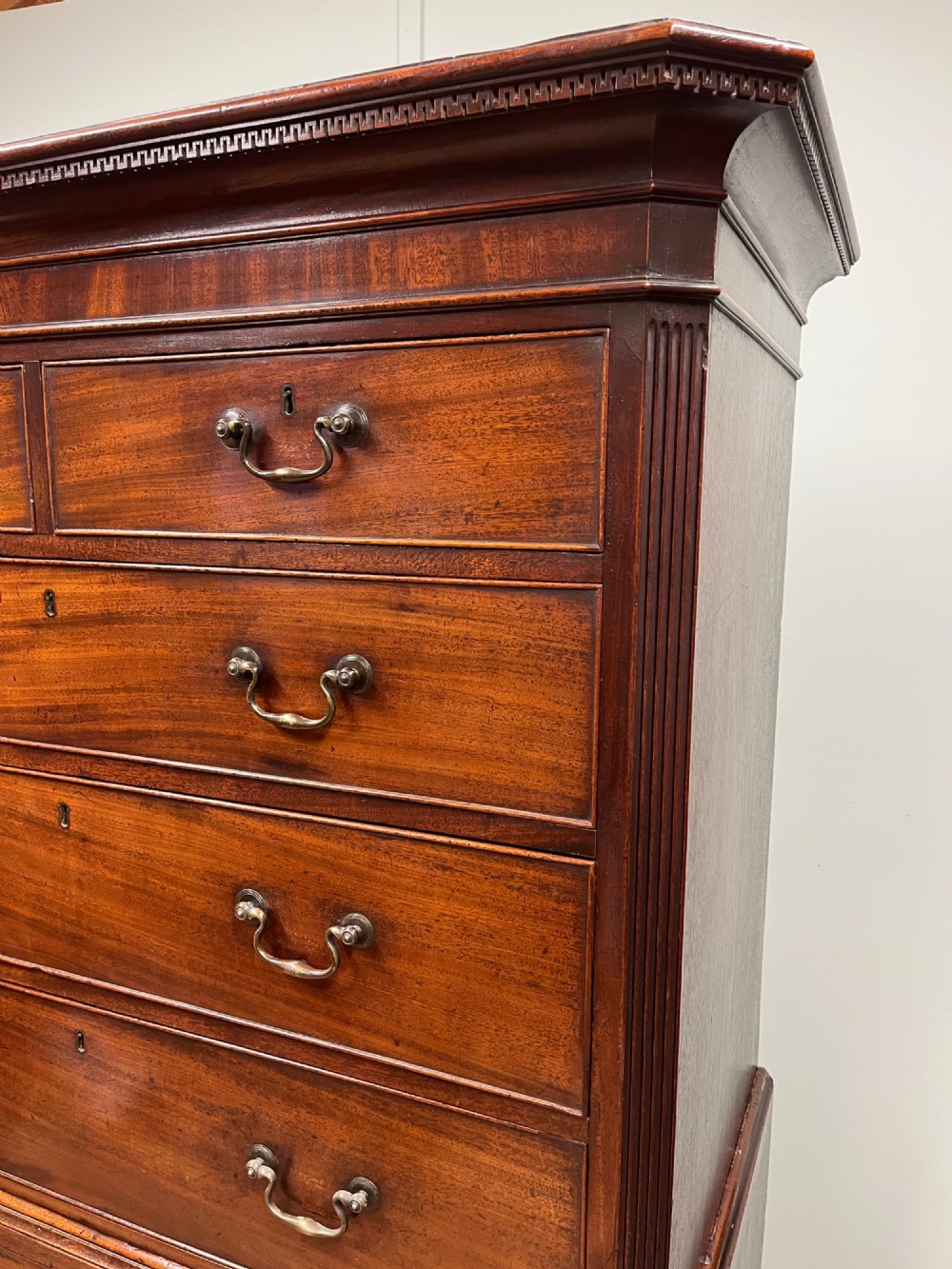 An 18th-century Georgian mahogany chest on chest featuring two short over six long graduated drawers with brass swan-neck handles and ogee bracket feet. View IV