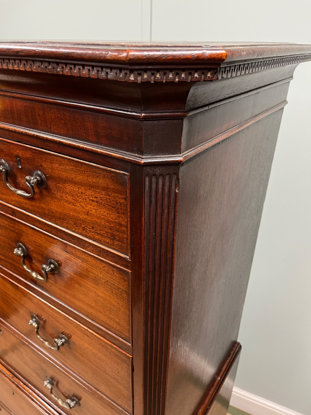 An 18th-century Georgian mahogany chest on chest featuring two short over six long graduated drawers with brass swan-neck handles and ogee bracket feet. View VI
