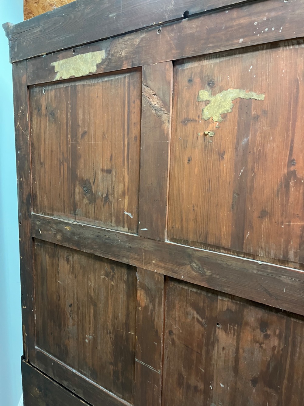 A nineteenth-century flame mahogany linen press featuring panelled cupboard doors above three lower drawers with brass swan-neck handles. View XI