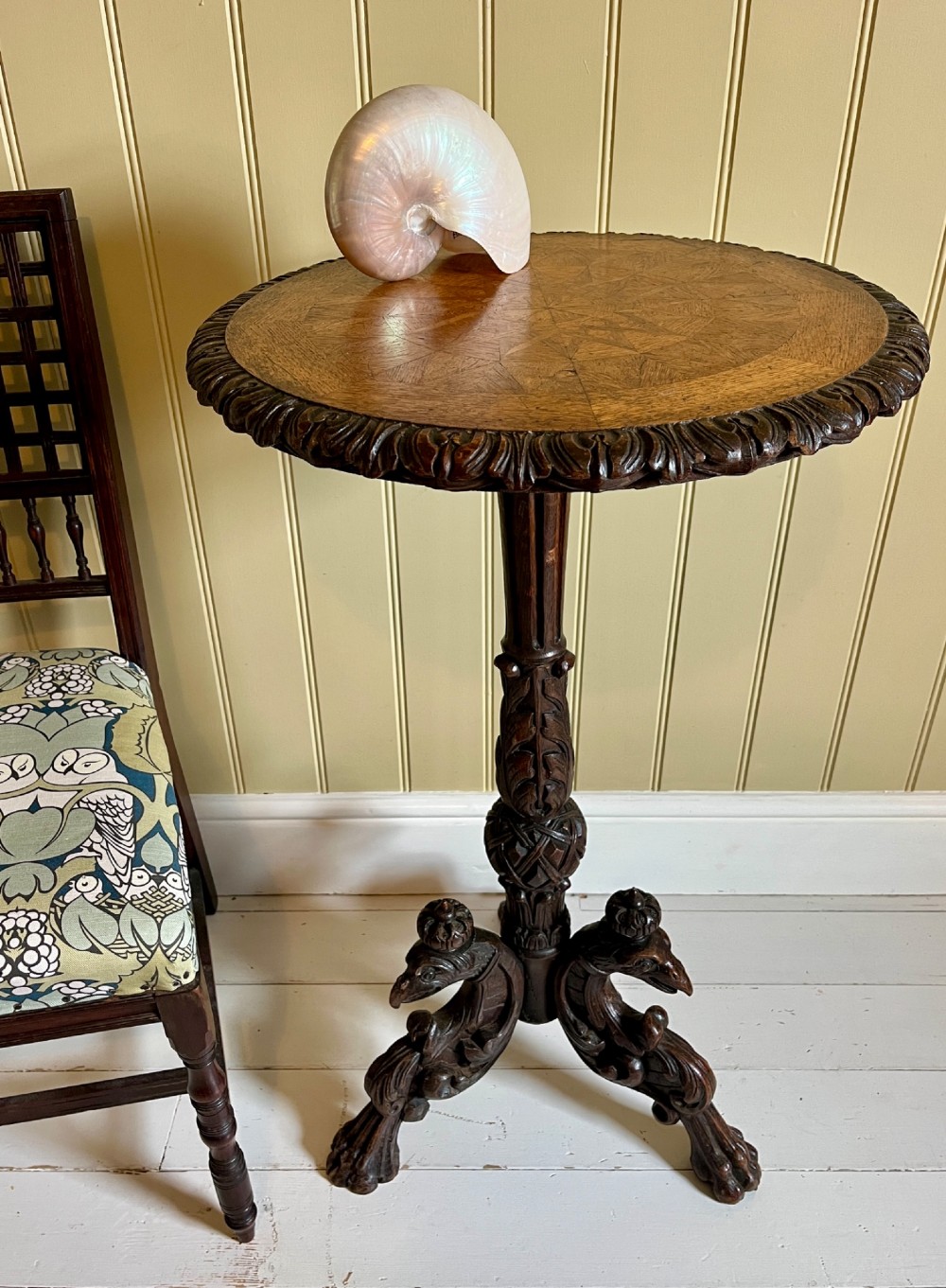 A 19th-century French oak side table with a circular parquetry top, carved gadrooned edge, ornate central column, and carved tripod legs.