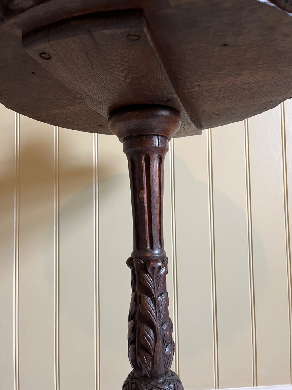 A 19th-century French oak side table with a circular parquetry top, carved gadrooned edge, ornate central column, and carved tripod legs. View VI