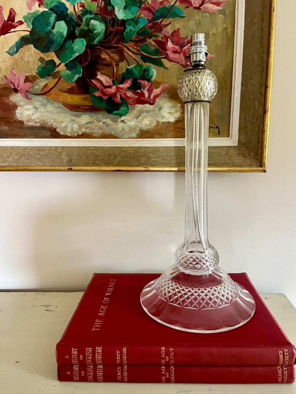 A clear cut crystal table lamp base featuring a fluted central column and a diamond-cut domed foot.