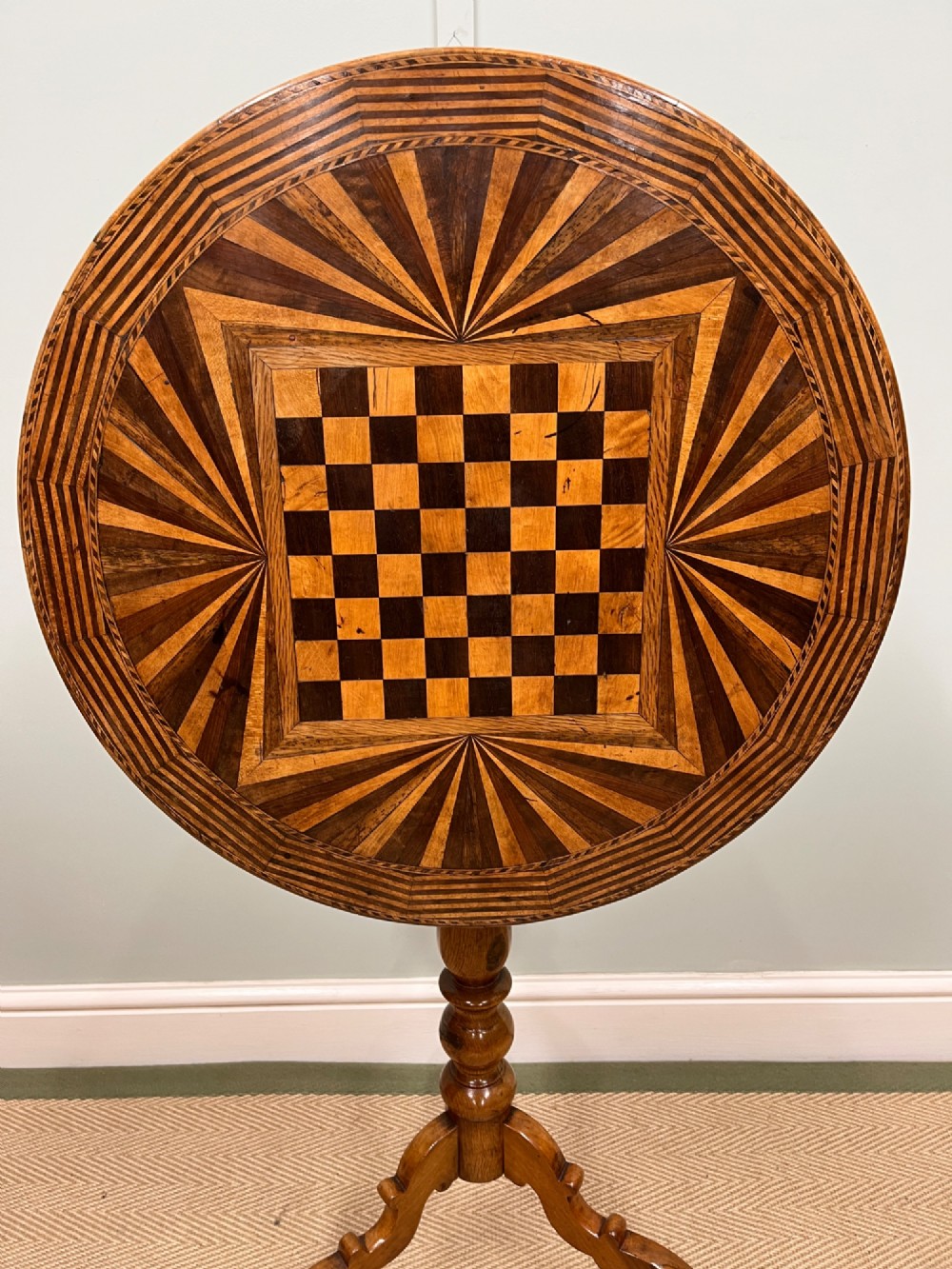 A nineteenth-century Italian circular tilt-top table featuring intricate geometric inlaid wood, a central chessboard design, and a turned pedestal on a tripod base. View II