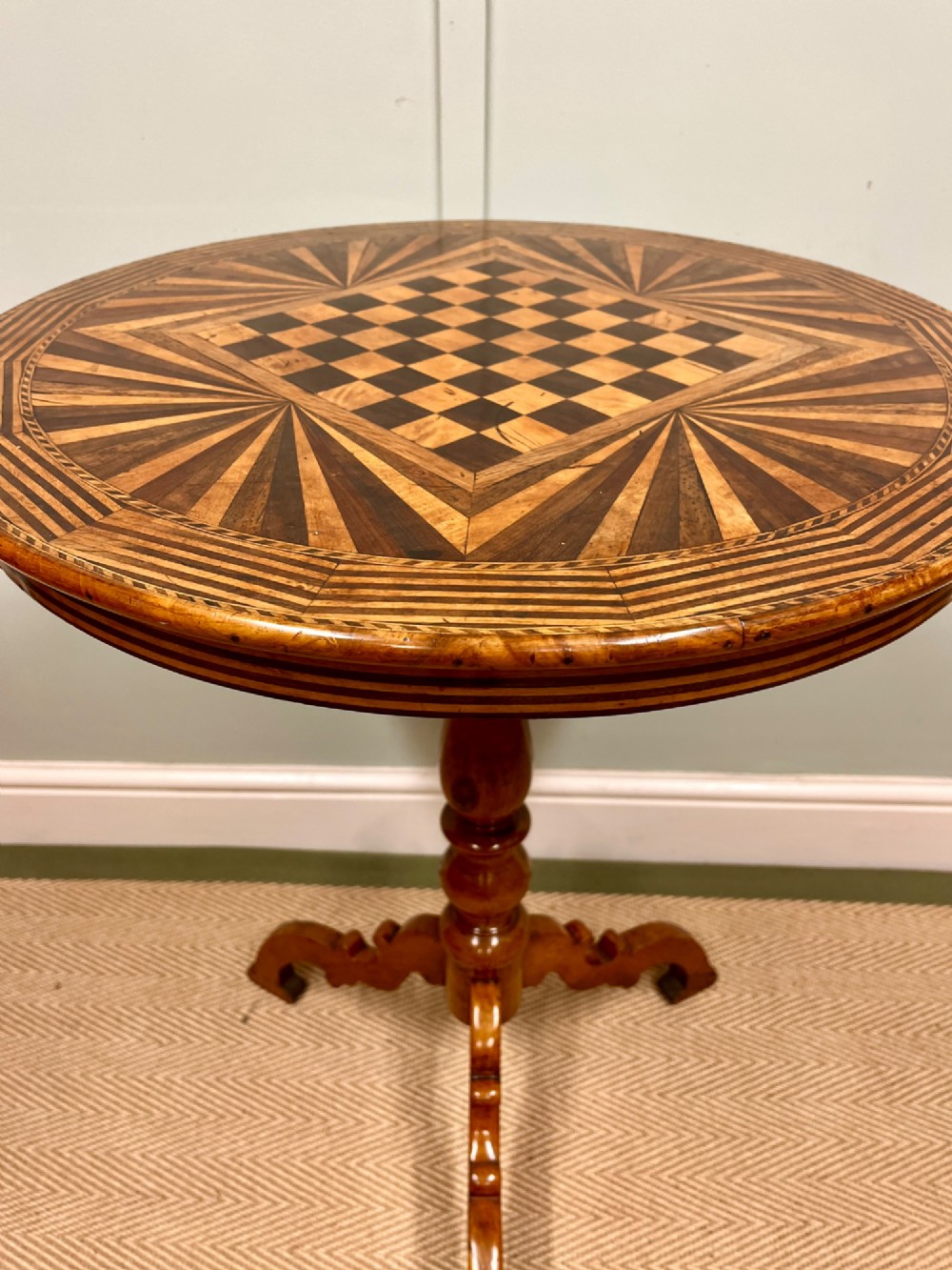A nineteenth-century Italian circular tilt-top table featuring intricate geometric inlaid wood, a central chessboard design, and a turned pedestal on a tripod base. View III