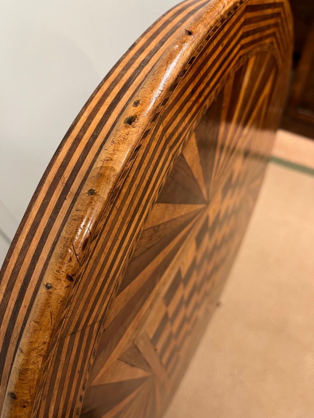 A nineteenth-century Italian circular tilt-top table featuring intricate geometric inlaid wood, a central chessboard design, and a turned pedestal on a tripod base. View V