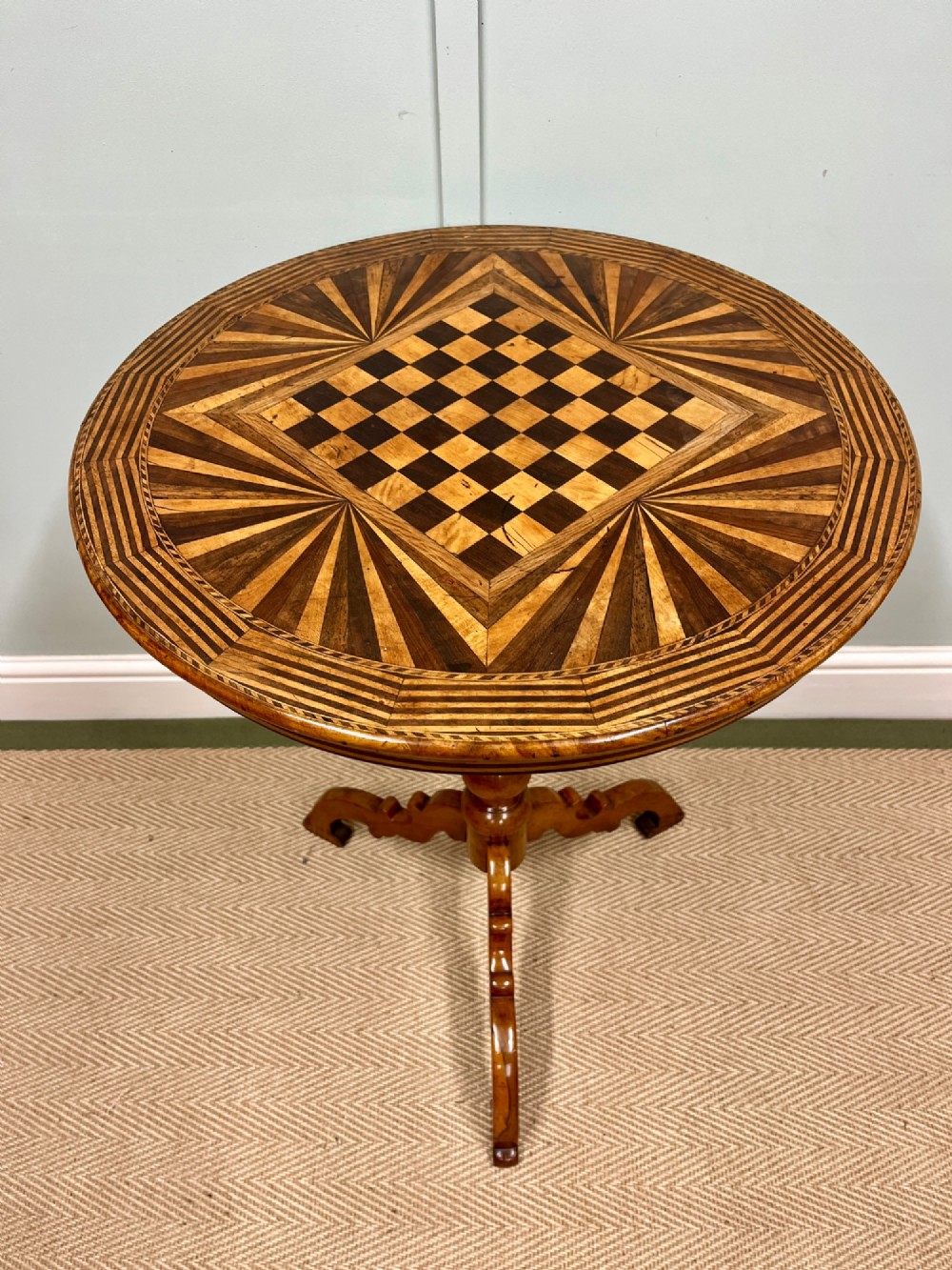 A nineteenth-century Italian circular tilt-top table featuring intricate geometric inlaid wood, a central chessboard design, and a turned pedestal on a tripod base. View VI