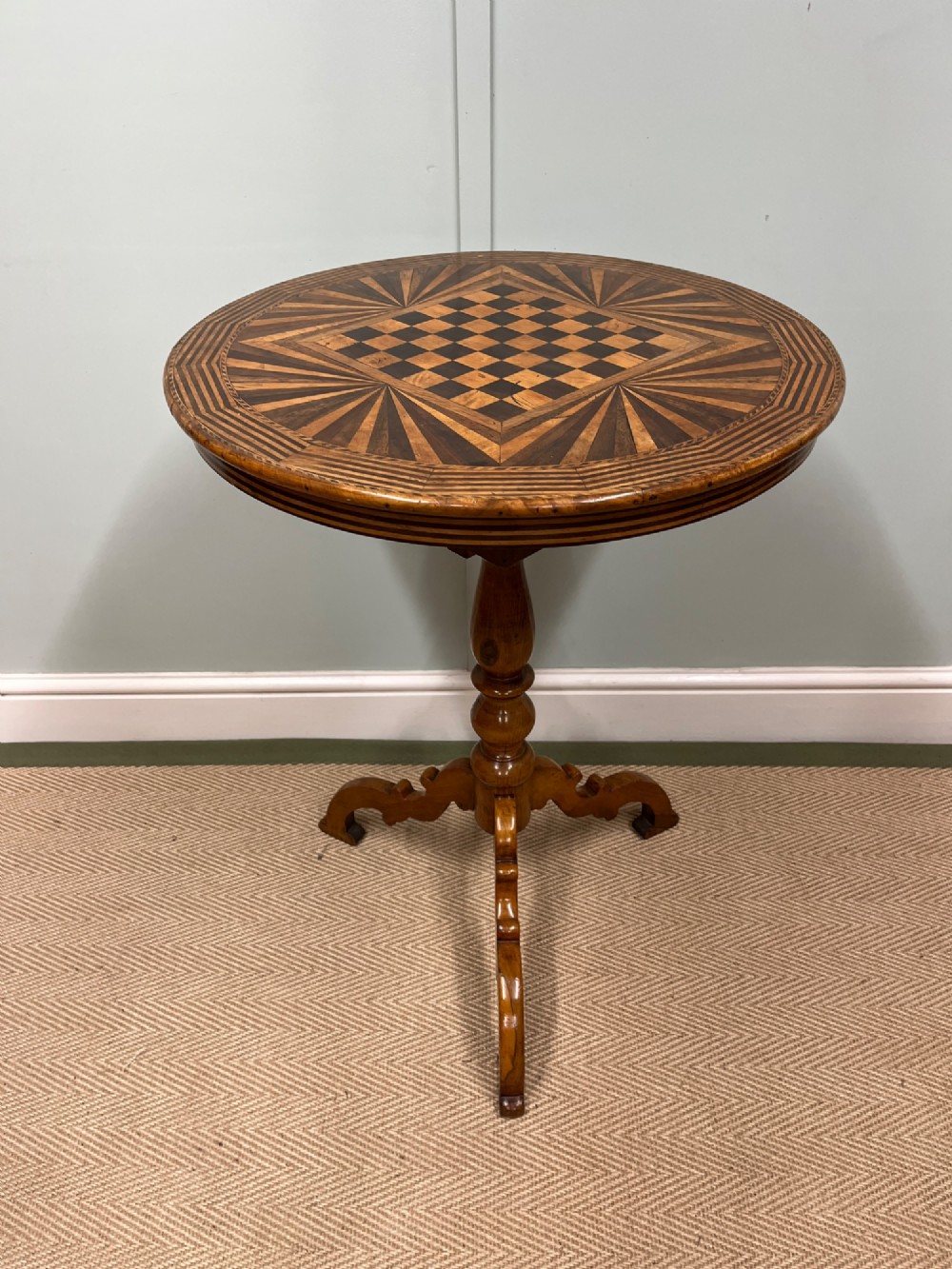 A nineteenth-century Italian circular tilt-top table featuring intricate geometric inlaid wood, a central chessboard design, and a turned pedestal on a tripod base. View VIII