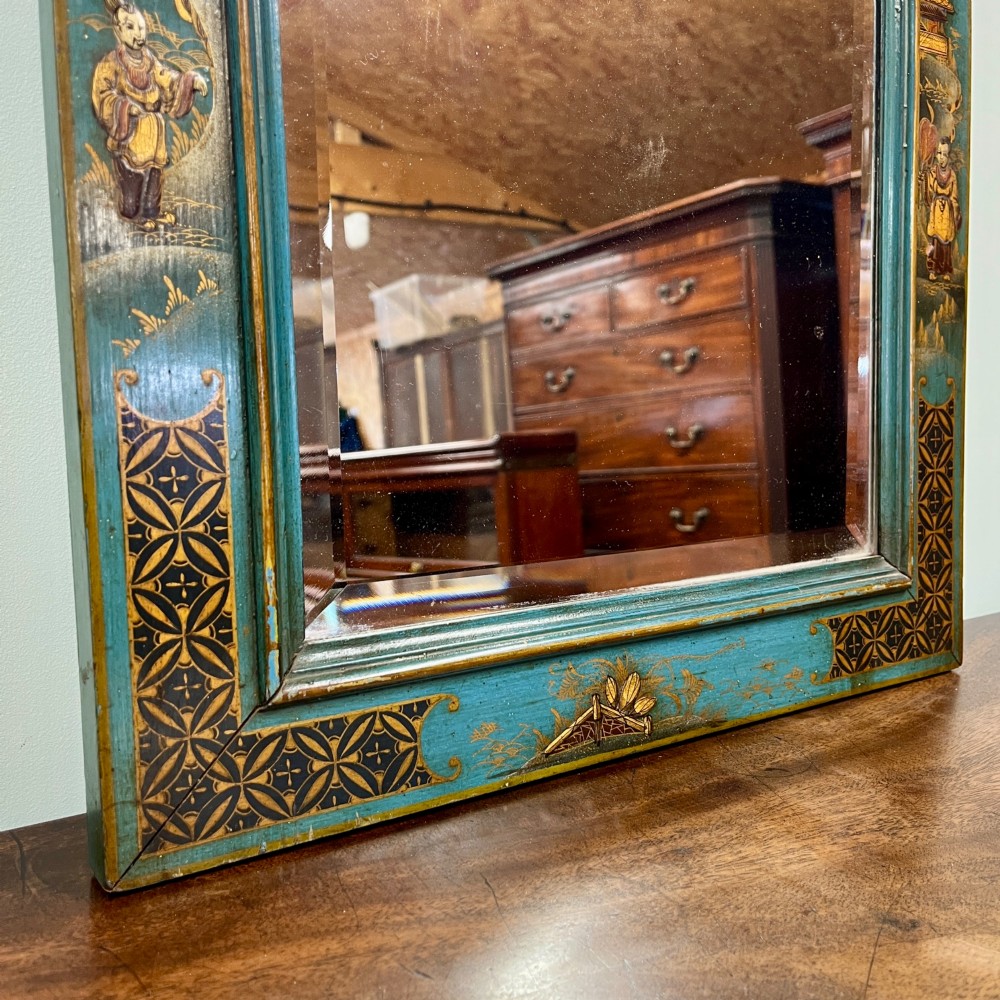 An Edwardian Chinoiserie wall mirror featuring a teal blue and gilt painted wooden frame with hand-painted Asian landscapes and a carved openwork cresting. View III