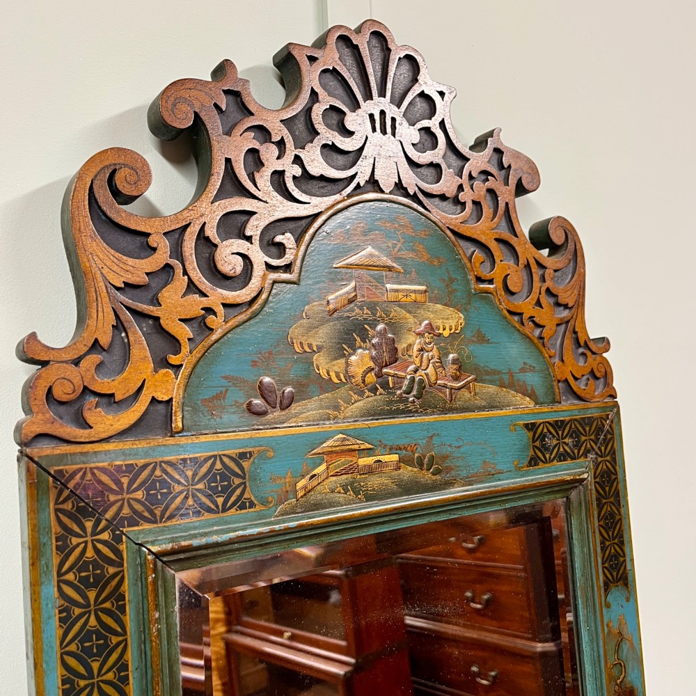 An Edwardian Chinoiserie wall mirror featuring a teal blue and gilt painted wooden frame with hand-painted Asian landscapes and a carved openwork cresting. View IV