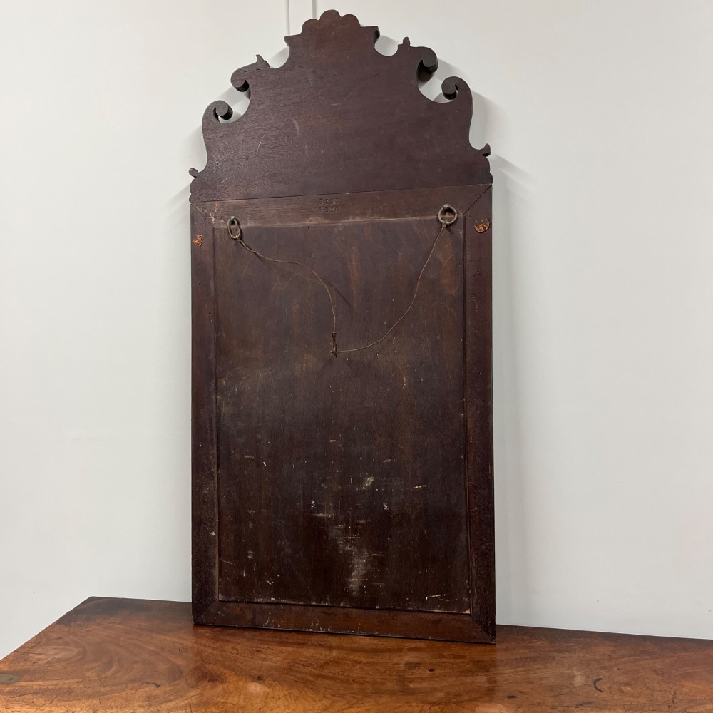 An Edwardian Chinoiserie wall mirror featuring a teal blue and gilt painted wooden frame with hand-painted Asian landscapes and a carved openwork cresting. View IX